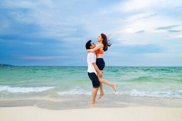 couple picking up and hugging on the sea beach at Koh MunNork Island, Rayong, Thailand