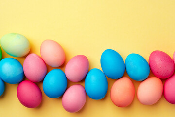Painted Easter eggs on yellow background top view
