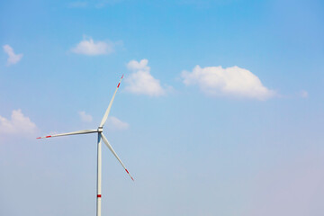 Fototapeta premium Modern wind turbine against blue sky. Energy efficiency