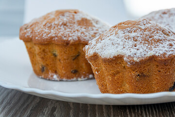 Cupcakes with raisins and powdered sugar on a plate. Close-up of confectionery. Image for project...
