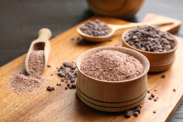 Black salt on wooden board, closeup view