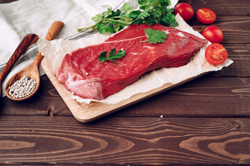 Raw meat beef fillet on brown wooden board