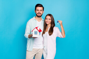 Photo of charming sweet young lovers dressed casual shirts holding home keys isolated blue color background