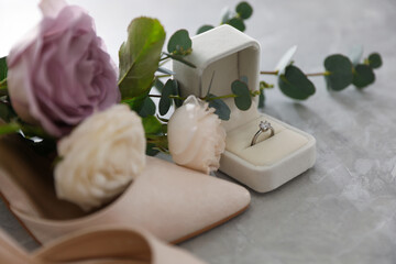 Wedding composition with engagement ring on light grey marble table, closeup. Bride dressing