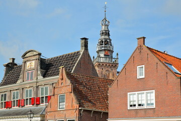Obraz premium Close-up on historic house facades in Monnickendam, North Holland, Netherlands, with the spire and clock tower of Speeltoren (The Carillon) in the background