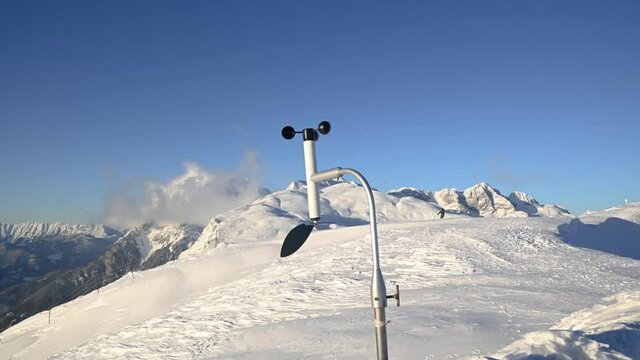 Weather station in mountain summit in cold winter. Alps mountains in Slovenia. Alps covered in snow. Rotating meteorological instrument anemometer used to measure wind speed