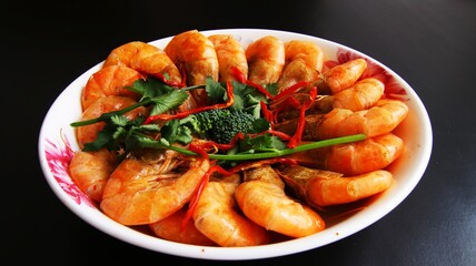 Chinese cuisine, shrimps garnished with green celery in a bowl