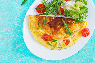 Breakfast. Omelette with tomatoes, cheese and arugula on white plate.  Frittata - italian omelet. Ketogenic, keto food. Top view, flat lay