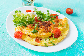 Breakfast. Omelette with tomatoes, cheese and arugula on white plate.  Frittata - italian omelet. Ketogenic, keto food.