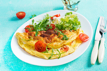 Breakfast. Omelette with tomatoes, cheese and arugula on white plate.  Frittata - italian omelet. Ketogenic, keto food.