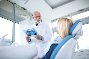 Obraz premium Dentist and patient looking at x-ray of teeth