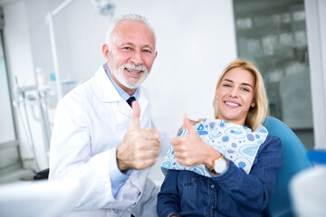 Smiling and satisfied experienced dentist and young patient