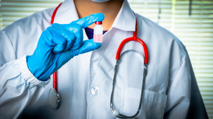 Doctor or scientist carries a vial of liquid vaccine for children and adults to test for COVID-19 vaccine in the lab. Concept COVID-19 vaccine