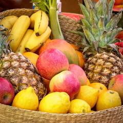 fruit basket with apples, bananas, lemons and pineapples