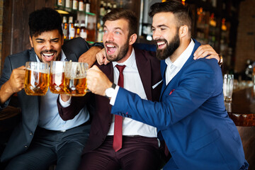 Business men in pub cheering for a sporting event