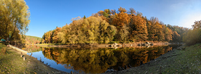 panorama autumn view at river Mze next city Stribro with boat and reflections in water on sunny day