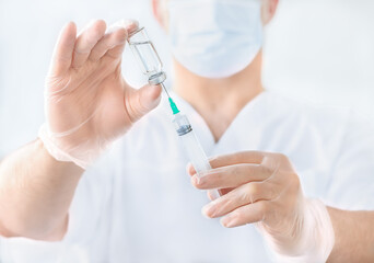 Fototapeta premium Doctor's hands with syringe and ampoule, injection