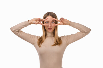 Portrait of optimistic blond girl showing peace sign over eye and smiling, white background. Just be cool about it