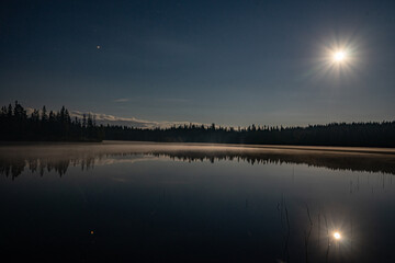 moon mirroring in nature on a lake