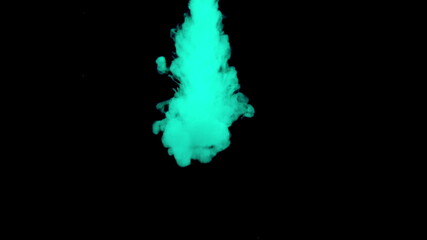 Real shot green paint drops in water. Ink swirling underwater. Cloud of ink collision isolated on black background. Close up view