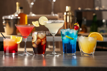 Different delicious cocktails on grey table in bar