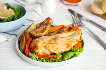 Delicious cooked chicken and vegetables on white wooden table, closeup. Healthy meals from air fryer