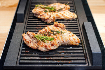 Chicken meat on grill. Spicy marinated chicken with herbs grilling on barbecue. Cooking on real kitchen