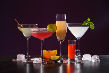 Many different alcoholic drinks on table against dark background