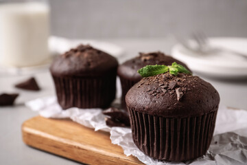 Delicious chocolate muffins served on grey table, closeup. Space for text