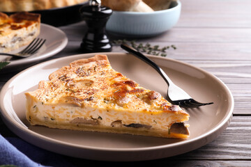 Delicious pie with mushrooms and cheese served on wooden table, closeup