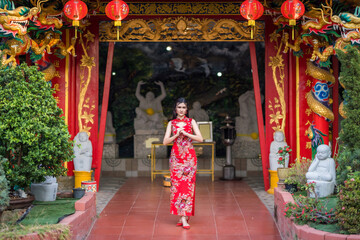 Asian woman wearing red traditional Chinese cheongsam decoration hold paper lanterns with the...