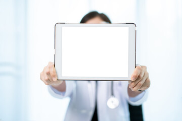 Unrecognizable specialist doctor holding an empty blank screen tablet isolated in white close up.