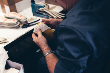 Manos trabajando en fábrica. Fábrica de calzado. Industria.	