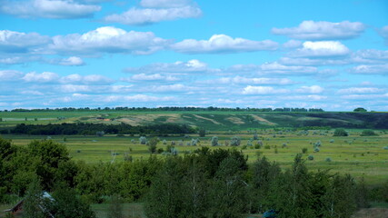 Fototapeta na wymiar View of green fields and blue sky with clouds