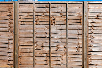 New wooden residential back yard garden fence which is usually made of pine or larch wood, stock photo image