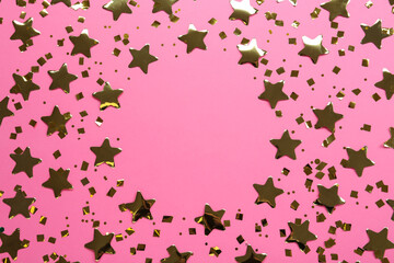 Frame of shiny golden confetti on pink background, flat lay. Space for text