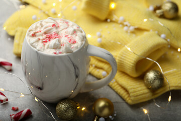 Composition with delicious marshmallow drink, festive decor and yellow sweater on light grey table