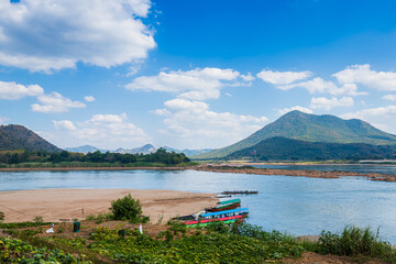 Riverside view of Mae Khong river and the a boat parked in port, Mountain views of Laos at the Kaeng Khud Khu rapids at Chiang Khan in Loei province, Thailand.