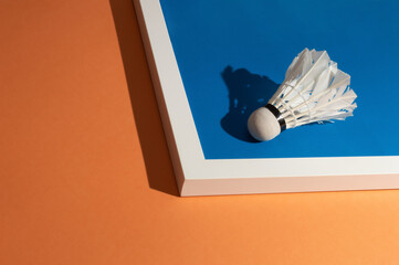 Blue and orange playground with white badminton ball. Minimalism art.