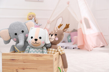 Wooden crate with cute toys in stylish playroom, space for text. Interior design © New Africa