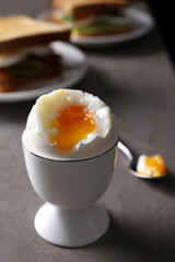 Soft boiled egg served for breakfast on grey table, closeup