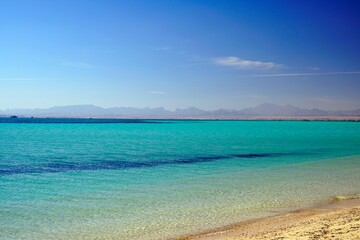 Landscapes of the red sea. Winter in Egypt. January in Africa. Azure water and sandy beach. Mountains on the horizon