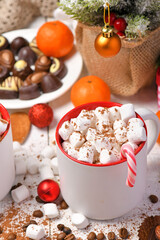 sweet food top view background for merry christmas or new year holiday decoration - chocolate candies, tangerines, cookies, marshmallow and cocoa latte on white wood