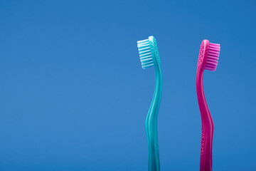 Pink and blue toothbrush with distance between like couple in fight