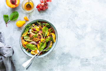 Fresh vegetable and pumpkin salad in a plate on a white stone background. Top view