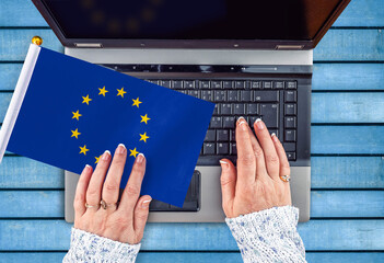 woman hands and flag of European Union on computer, laptop keyboard
