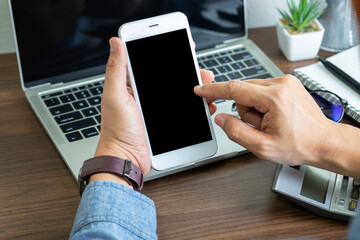 Close-up shot of Businessman hands using, holding smartphone or mobile mockup with blank screen display at office desk. Phone technology, digital modern design can use touch screen with copy space.