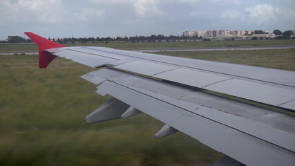 The plane travels on the ground. View from the airplane window to the wing.