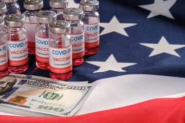 American flag, coronavirus vaccine vials, syringe and money for purchase or trading vaccine concept. Copy space for text