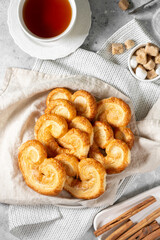 Puff. Flaky sugar Palmiers cookies in a ceramic plate on a light background. Sweet homemade cakes	